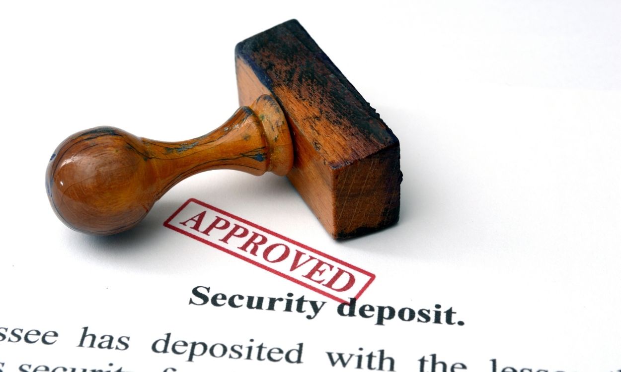 A security deposit document with the word approved stamped in red