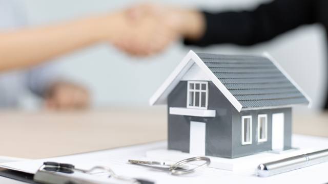 a home figurine on a purchasing contract