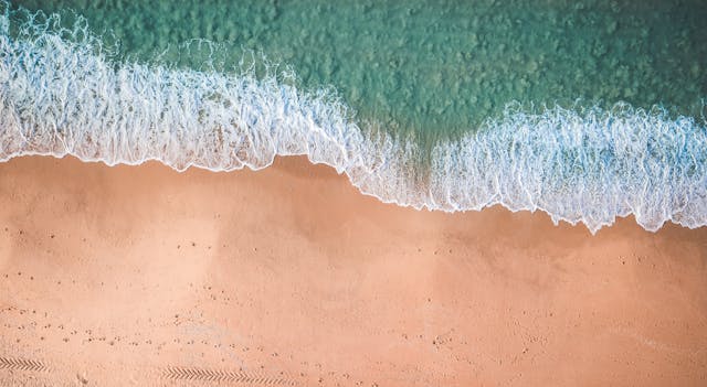 an overhead shot of a white sand beach